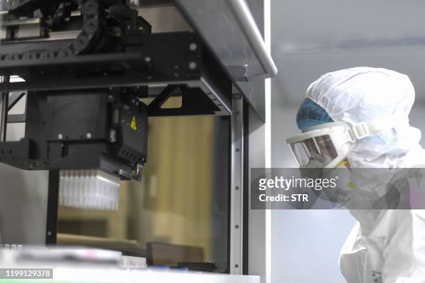 This photo taken on February 6, 2020 shows a laboratory technician monitoring samples from people to be tested for the new coronavirus at "Fire Eye"...