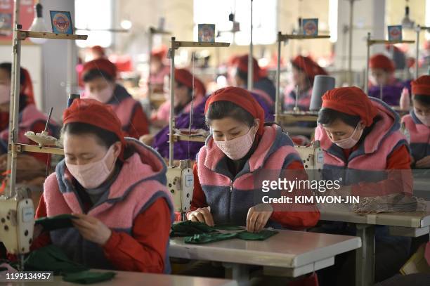 In this photo taken on February 6 workers of Songyo Knitwear Factory in Pyongyang produce masks for protection against the new coronavirus. - At...
