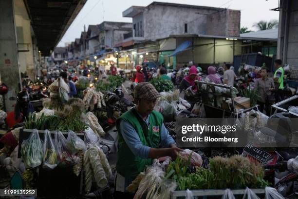 Vendor arranges vegetables at a market in the port city of Balikpapan in East Kalimantan, Borneo, Indonesia, on Tuesday, Nov. 26, 2019. For Jakarta,...