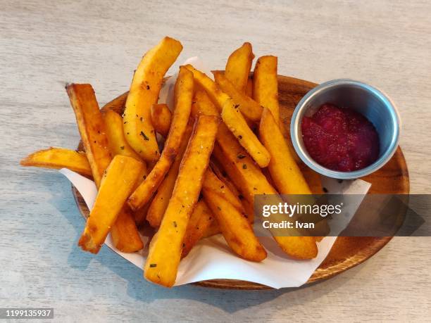 heap of french fries with tomato sauce  in a wooden plate - fast food french fries stock pictures, royalty-free photos & images