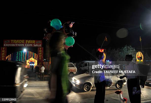 Street vendor sells toys on the banks of Dal Lake in Srinagar on July 26, 2011. The tourism industry is hoping that cool summer weather will herald a...