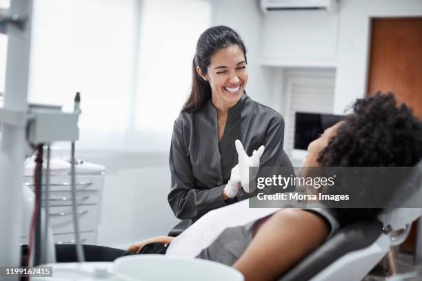 dentista feliz con paciente en clínica dental - dentistas fotografías e imágenes de stock