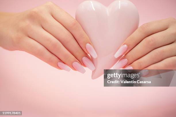 beautiful baby boomer nails holding a porcelain heart - heart nail art stock pictures, royalty-free photos & images