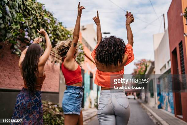 三個年輕女子散步和跳舞 - woman bum 個照片及圖片檔