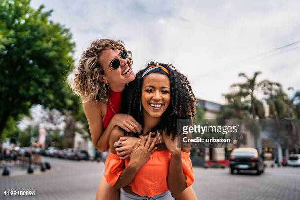 two beautiful women having fun - piggyback stock pictures, royalty-free photos & images