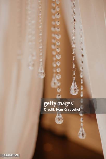 blur golden bokeh from beautiful crystal. wedding arch decoration close-up. pendants made of crystals close-up. vertical - light blur stock-fotos und bilder