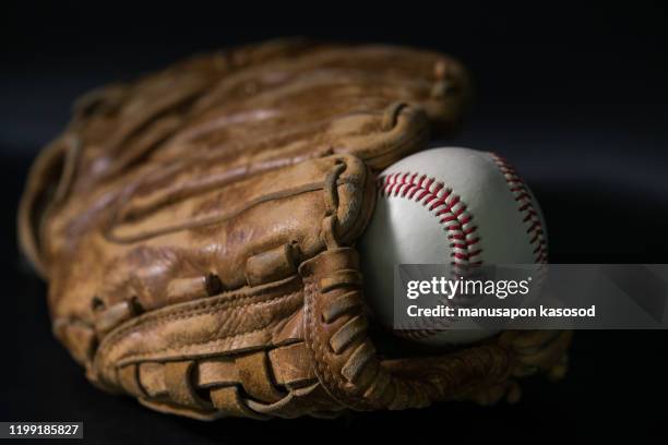 baseball in a glove on black background. - lace glove 個照片及圖片檔