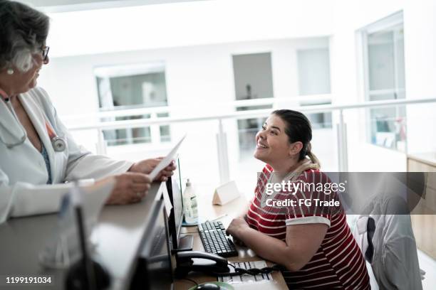 female senior doctor at hospital reception / secretary - secretary stock pictures, royalty-free photos & images