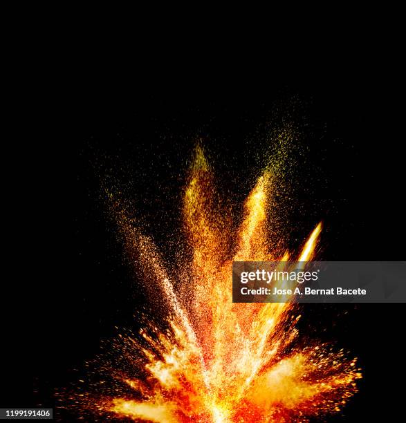 explosion by an impact of a cloud of particles of powder and smoke of color orange and yellow on a black background. - colourful studio shots stock-fotos und bilder