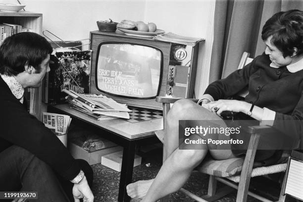 English actor and comedian Michael Palin and his wife Helen Gibbins watch a broadcast of an episode of 'Do Not Adjust Your Set' in London in February...