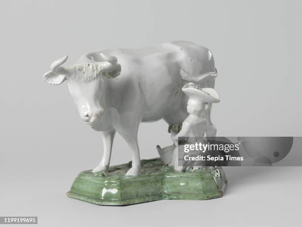 Cow with milk star, on a green pedestal, Sculpture of faience. An undecorated cow stands on a green painted pedestal. On the left side of the cow is...