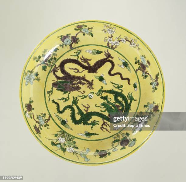 Saucer dish with pearl chasing dragons against a yellow ground, Porcelain dish with round wall, painted in underglaze blue and on biscuit green,...