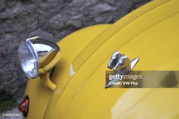 Two horses in a yellow Citro'n 2CV.
