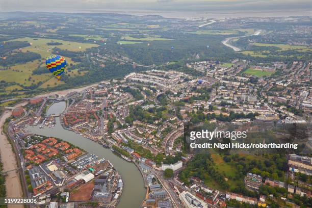 a hot-air balloon flying over the city of bristol during the bristol international balloon fiesta, bristol, england, united kingdom, europe - bristol balloons stock pictures, royalty-free photos & images