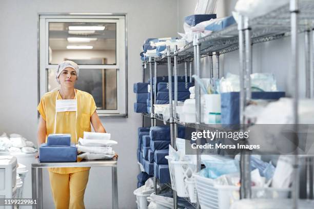 docteur avec des approvisionnements médicaux dans la salle de stockage - fourniture médicale photos et images de collection