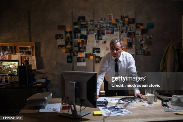 mature police detective looking at computer late at night in his office - sticky-notes-covering-computer-monitor stock pictures, royalty-free photos & images
