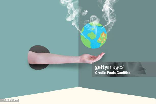 an arm coming from a hole in a wall with a world globe above the hand. - water globe stock pictures, royalty-free photos & images