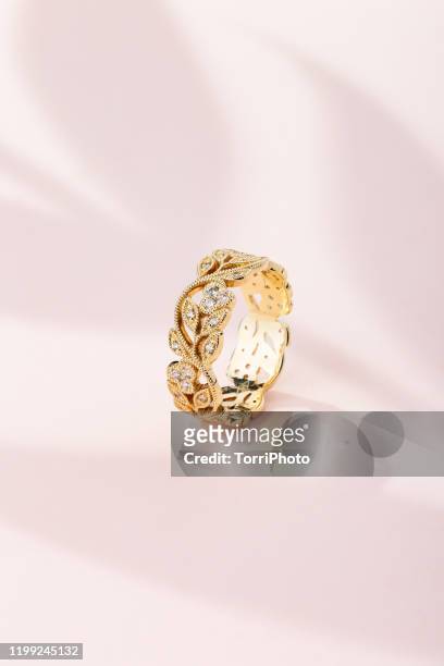 floral design gold ring with diamonds on pink background with leaves shaped shadow - ring shaped stock pictures, royalty-free photos & images