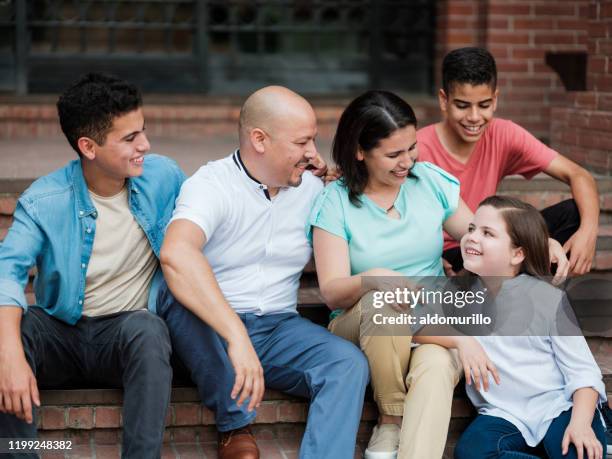 happy latin family with three children sitting outside - step sibling stock pictures, royalty-free photos & images