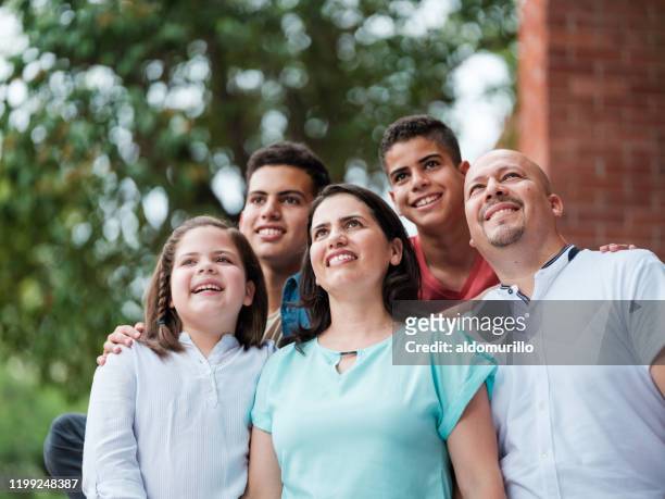 mexican family with three children looking up and smiling - ten to fifteen stock pictures, royalty-free photos & images