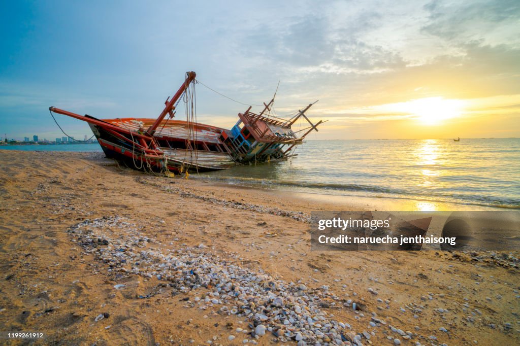 An old shipwreck boat abandoned stand on beach. Shipwreck in Kratinglay beach Chonburi Thailand