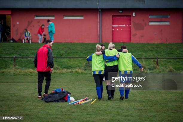 supporting a team mate - injured football player stock pictures, royalty-free photos & images