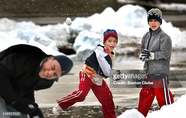 Bill Brodnitzki of Natick has a snowball fight with sons Will, center and Tom Brodnitzki using the ice-shavings from the Frog Pond on Boston Common....