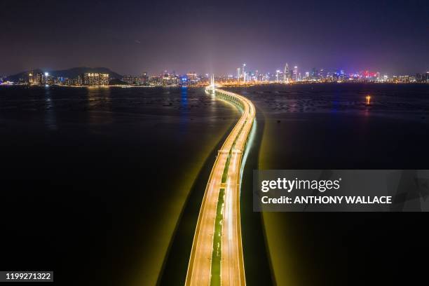 This aerial photo taken in Hong Kong on February 6 shows the Shenzhen Bay Bridge and the skyline of Shenzhen in the background. - Hong Kong on...