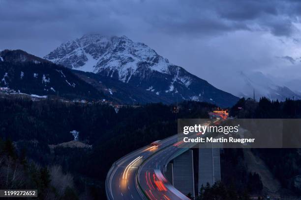cars with light on brenner pass road bridge with mountain in background. innsbruck, brenner pass, tirol, austria, europe. - brennerpas stockfoto's en -beelden