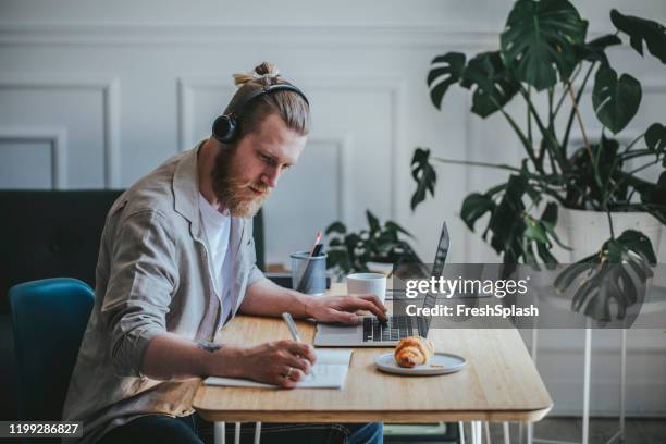 freelancer using a laptop - man bun stock pictures, royalty-free photos & images