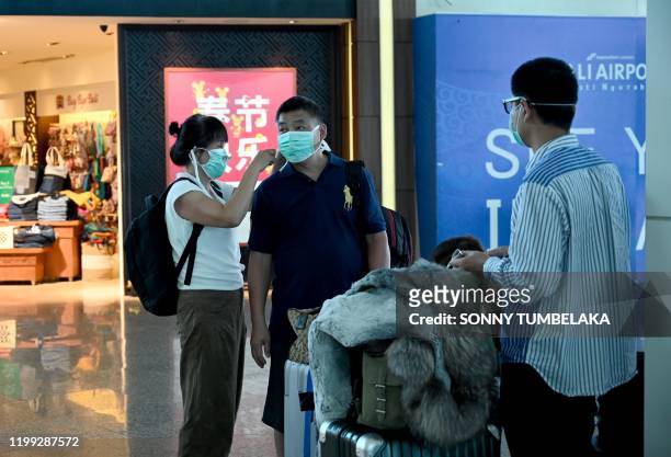 Chinese tourists wearing facemasks arrive Ngurah Rai airport in Denpasar on February 8, 2020. - The new coronavirus that emerged in a Chinese market...