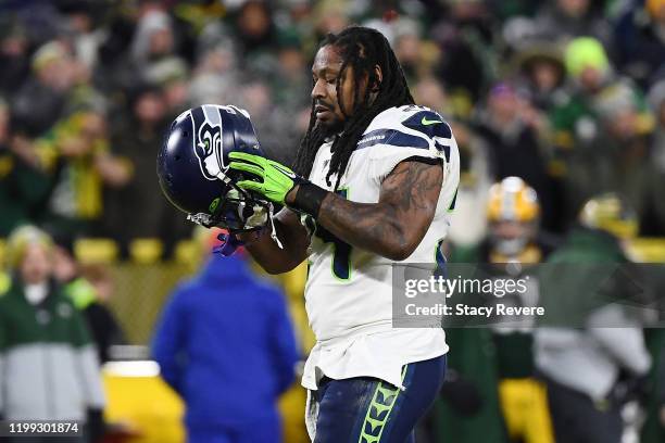 Marshawn Lynch of the Seattle Seahawks walks to the huddle during the NFC Divisional Playoff game against the Green Bay Packers at Lambeau Field on...