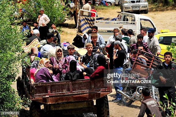 Syrian internally displaced persons arrive to a makeshift camp in the northern city of Idlib, near the Turkish village of Guvecci in Hatay, on June...