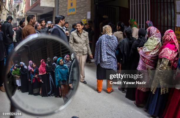 Indian Muslim women wait in queue to cast their votes outside a polling station on February 8, 2020 in Delhi, India. The Muslim-majority locality has...
