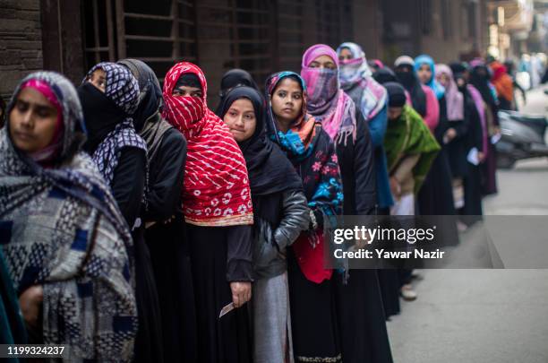 Indian Muslim women wait in queue to cast their votes outside a polling station polling station on February 8, 2020 in Delhi, India. The...