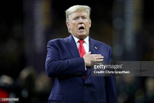 President Donald Trump stands for the national anthem prior to the College Football Playoff National Championship game between the Clemson Tigers and...