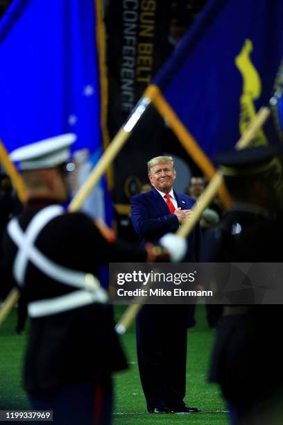 President Donald Trump stands for the national anthem prior to the College Football Playoff National Championship game between the Clemson Tigers and...