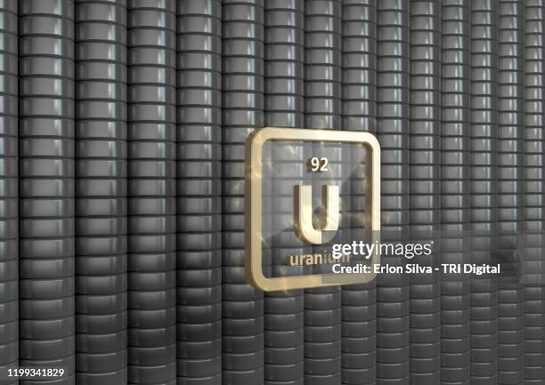 symbol of uranium in front of a stack of enriched uranium - enriched uranium stock pictures, royalty-free photos & images