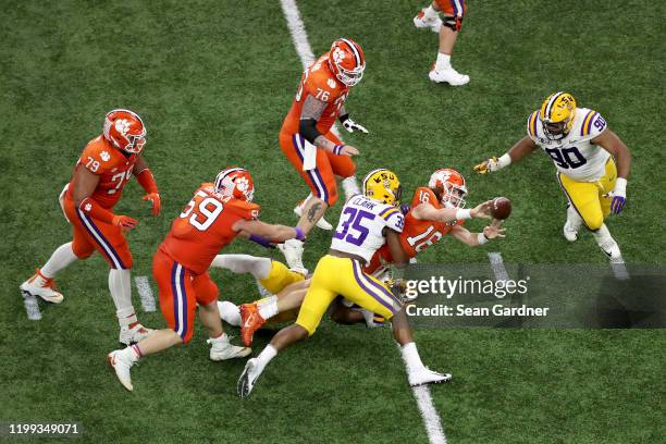 Trevor Lawrence of the Clemson Tigers is sacked by Damone Clark of the LSU Tigers in the College Football Playoff National Championship game at...