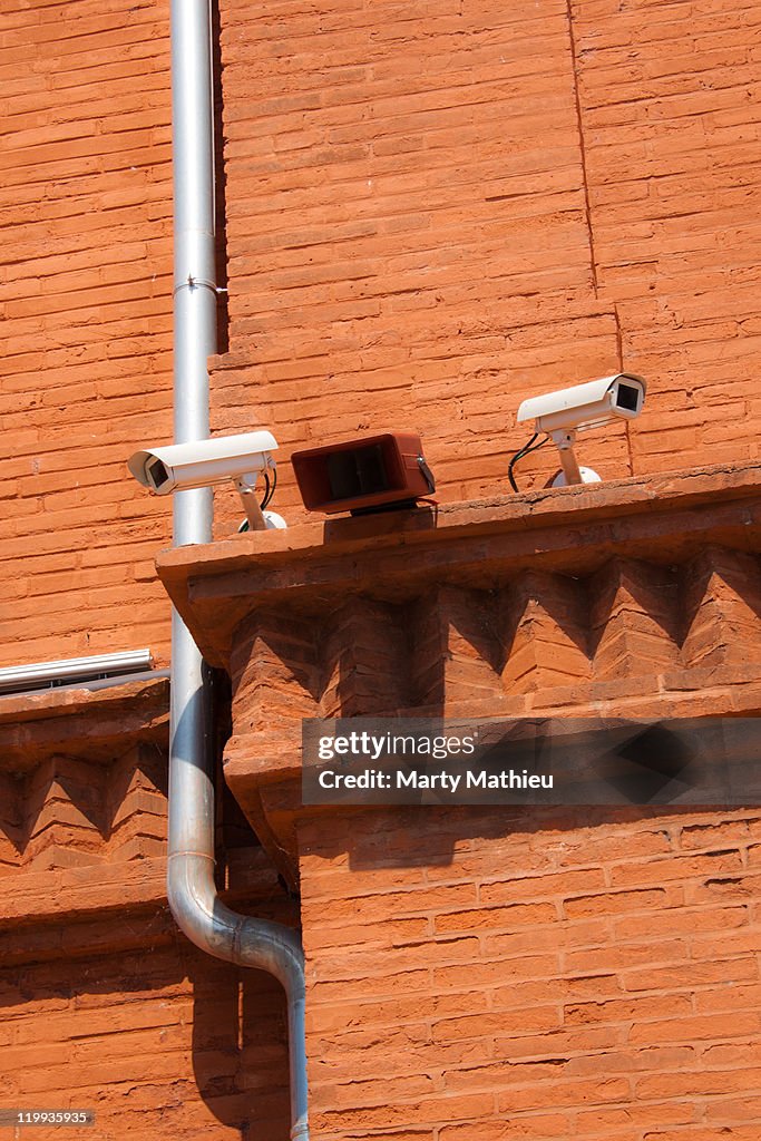 Surveillance camera on brick wall