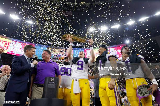 Joe Burrow of the LSU Tigers and Grant Delpit of the LSU Tigers celebrate with the trophy after defeating the Clemson Tigers 42-25 in the College...