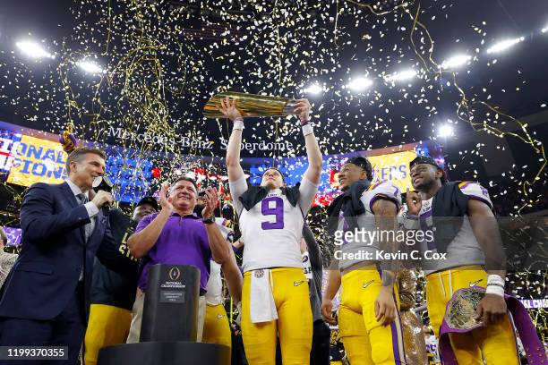 Head coach Ed Orgeron of the LSU Tigers, Joe Burrow of the LSU Tigers and Grant Delpit of the LSU Tigers celebrate with the trophy after defeating...