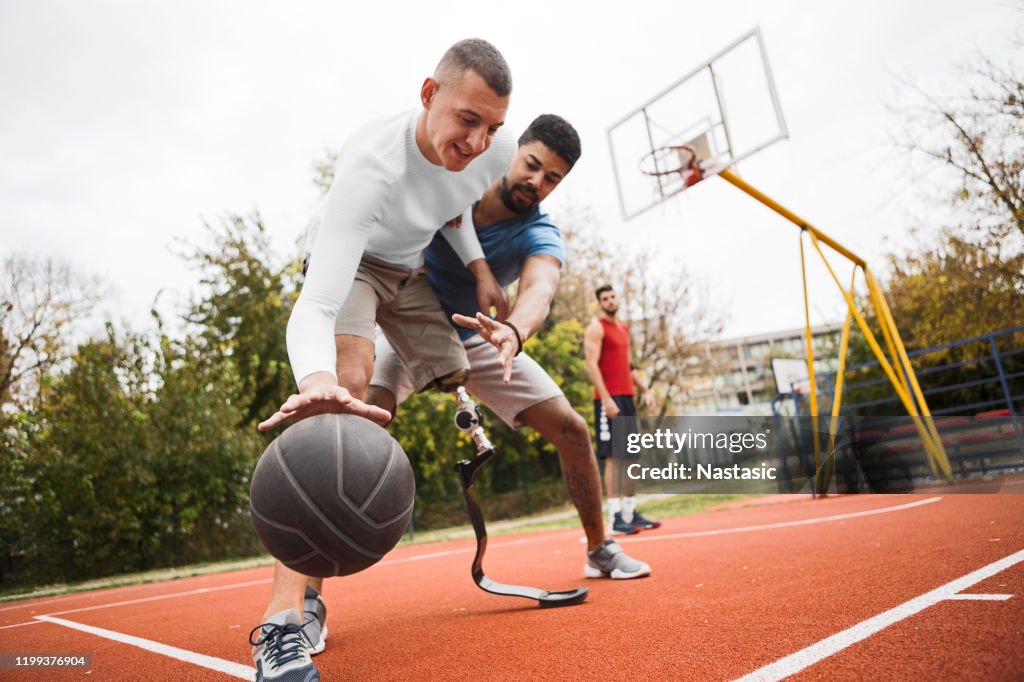 Young man with artificial limb on a basketball court
