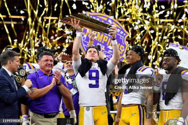 Joe Burrow of the LSU Tigers raises the National Championship Trophy with Ed Orgeron, Grant Delpit, and Patrick Queen after the College Football...