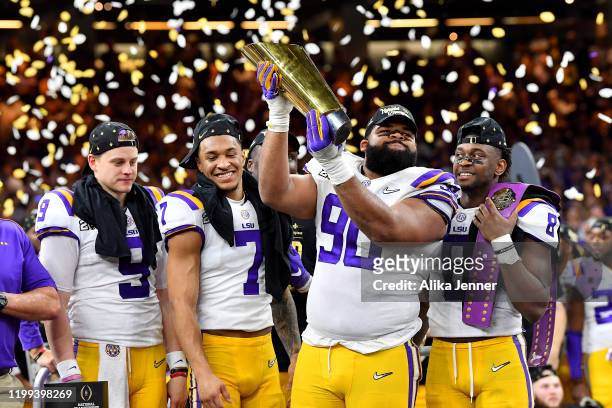 Rashard Lawrence of the LSU Tigers raises the National Championship Trophy with Joe Burrow, Grant Delpit, Patrick Queen, and Rashard Lawrence after...