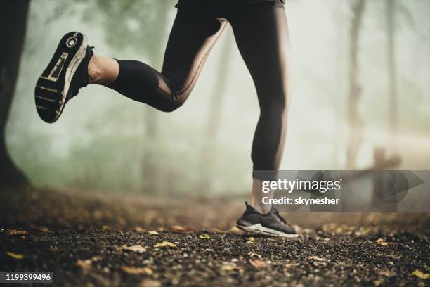 悪天候時に走っている認識できないアスリート。 - running legs ストックフォトと画像