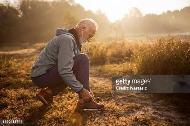 senior man knyta skosnören på sport sneakers - tied up bildbanksfoton och bilder