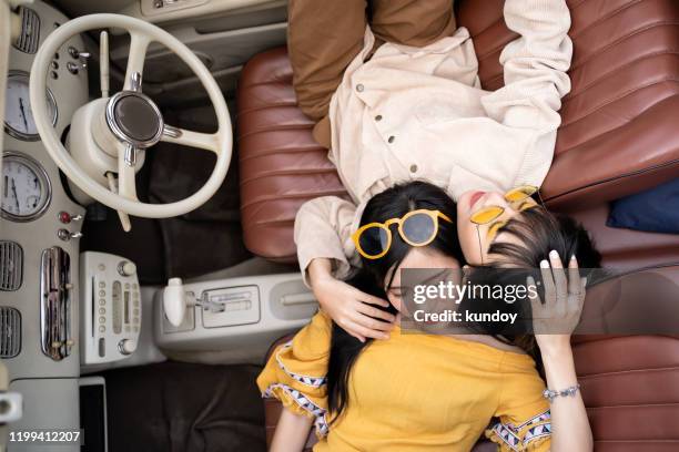 portrait of young woman friends sleeping in car together. relaxing concept. - couple sleeping in car stock-fotos und bilder