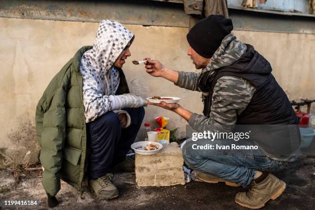 An Algerian migrant named Ghilas helps to eat a compatriot named Adir wounded in the arms by the Croatian border police while trying to cross into...