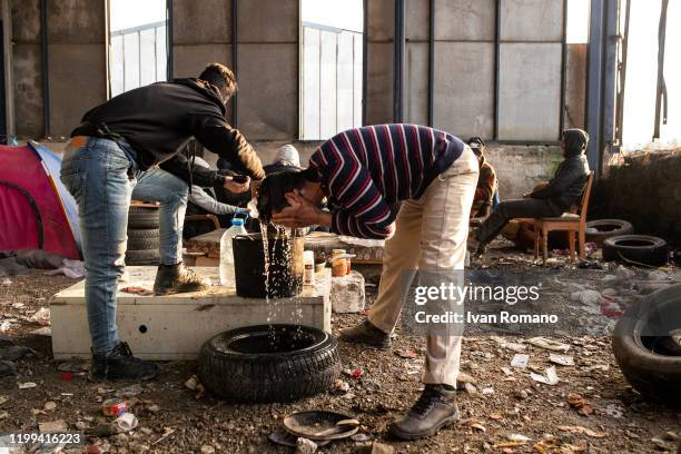 Algerian migrant washes himself inside an industrial warehouse on January 12, 2020 in Velika Kladuša, Bosnia and Herzegovina. About 5,000 people are...